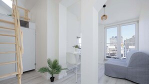 A modern apartment with a loft area, a dining area, and a grey sofa. - Functional Apartment for 6 Persons | Air Conditioning, Balcony (Warszawa)
