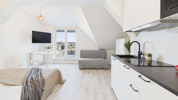 Un apartamento moderno con cocina, comedor y balcón con vistas a la ciudad.