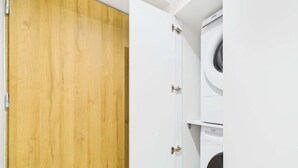 A room with a wooden door and a white wall.