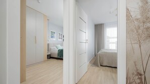 A modern bedroom with a bed, a wardrobe, and a bedside table. - Comfortable Apartment for 6 Persons | Parking | Balcony (Warszawa)