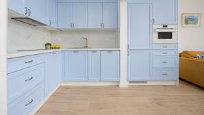 Una cocina con armarios azul claro, una encimera blanca y una planta amarilla.