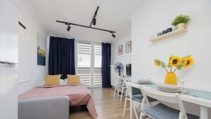 A modern bedroom with a bed, bedside table, and a desk with chairs.
