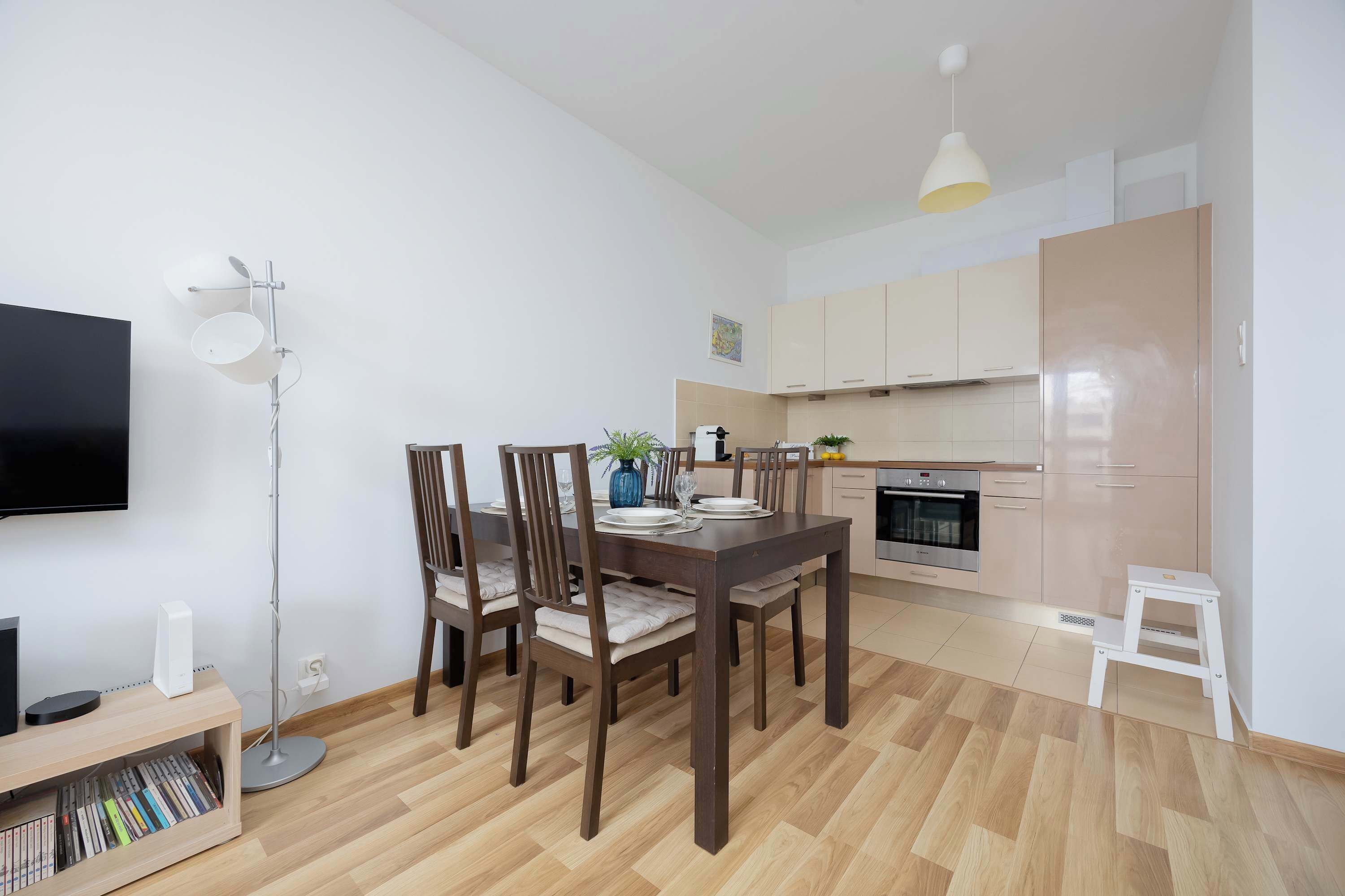 Um apartamento moderno com área de jantar, cozinha e televisão de tela plana.