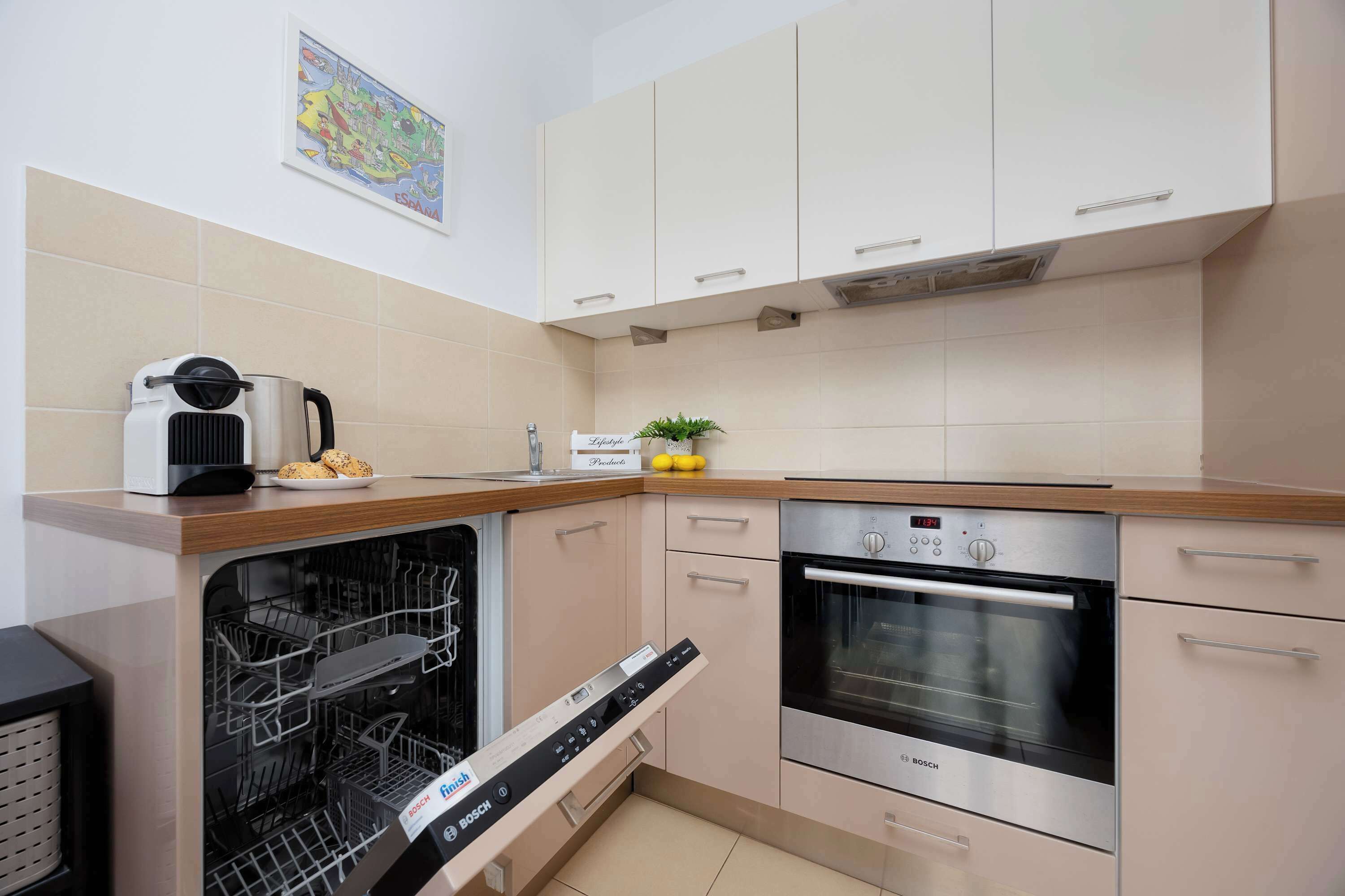 Una cocina compacta con lavavajillas Bosch, horno y cafetera sobre la encimera.