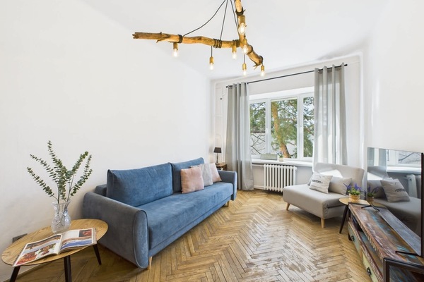 Cozy living and sleeping area with a stylish sofa bed and natural light streaming in through large windows.