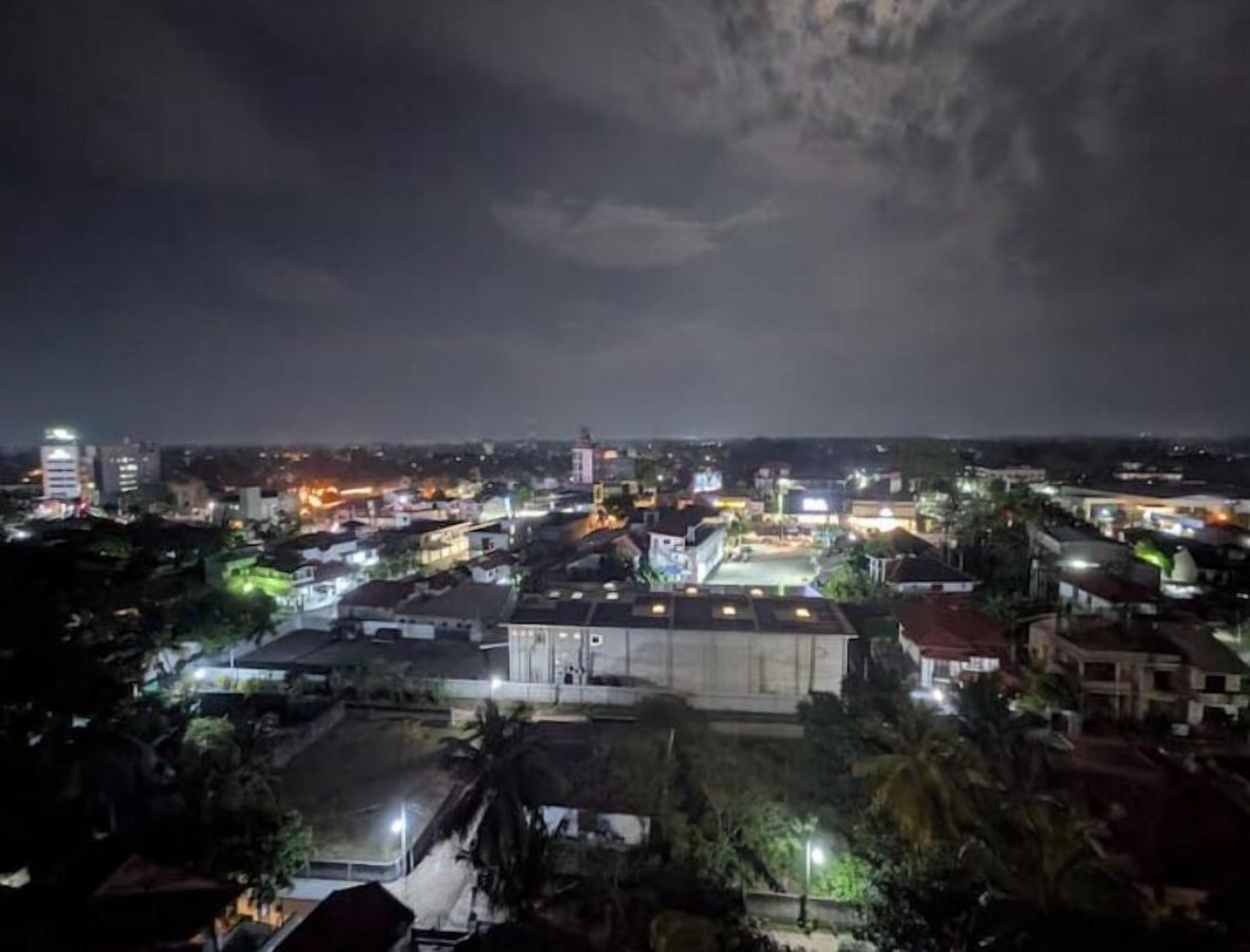 A nighttime view of a cityscape with buildings and streetlights.