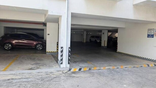 Un parking à plusieurs niveaux où sont garées plusieurs voitures.
