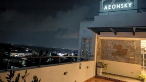 A hotel named AEONSKY with a modern design, a balcony, and a view of the city at night. - Urban 3BR Apt• Hi-Speed Wi-Fi• Roof Top Pool & Gym (Negombo)