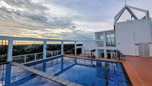 A modern rooftop pool with a clear view of the cityscape during sunset. - Urban 3BR Apt• Hi-Speed Wi-Fi• Roof Top Pool & Gym (Negombo)