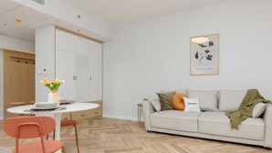 Una sala de estar moderna con un sofá, una mesa de comedor con sillas y una pequeña mesita auxiliar.