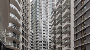 Un moderno edificio de gran altura con varios balcones y ventanas amplias.