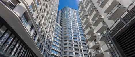 Un edificio alto con múltiples balcones y ventanas amplias.