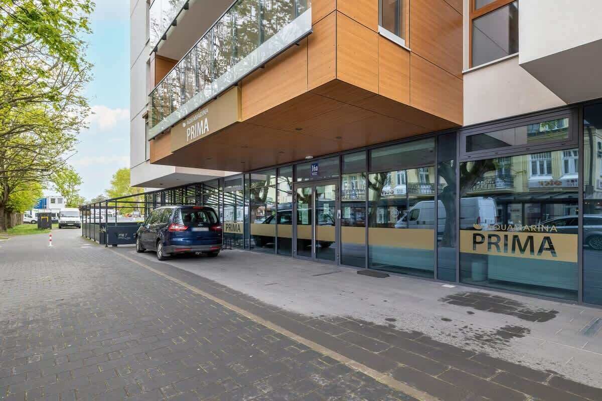 Un bâtiment moderne doté d’une façade en verre et d’une enseigne indiquant « PRIMA ».