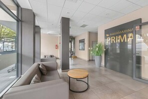 A modern lobby with a sofa, a round table, and a large potted plant.