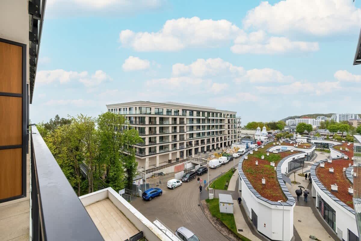 Een modern gebouw met een plat dak en een binnenplaats met een golvend ontwerp.