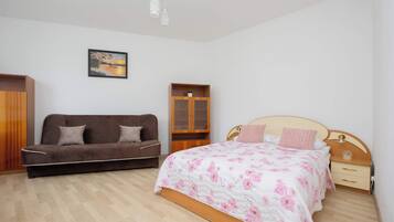 A bright, comfortable bedroom with a double bed and a sofa bed. The bedroom has sleeping space for 4 people.