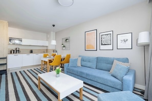 Uma sala de estar moderna com sofá, mesa de centro e espaço de jantar.