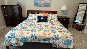 A bedroom with a bed, a nightstand, a dresser, a bench, a lamp, a mirror, and a wall painting. - 3-bedroom house in beautiful Santa Rosa Beach!4,500/month. 3-6 month rental only (Santa Rosa Beach)
