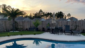 A backyard with a swimming pool, patio furniture, and a wooden fence. - 3-bedroom house in beautiful Santa Rosa Beach!4,500/month. 3-6 month rental only (Santa Rosa Beach)