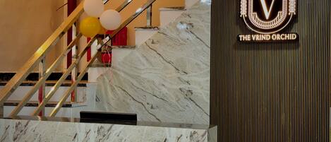 A marble staircase with a logo and text on the wall.