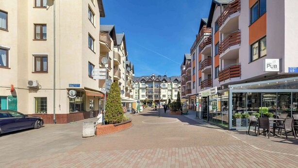 Un hotel con varios pisos, terraza al aire libre y cielo despejado.
