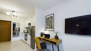 Eine moderne Küche mit Einbauofen, Kühlschrank und Essbereich mit Holztisch und Stuhl.