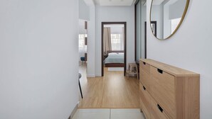 Ein schmaler Flur mit einem Holzschrank und einem Spiegel auf der rechten Seite.