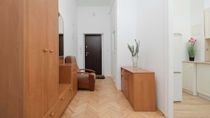 Ein Flur mit Holzmöbeln, einer Tür und einem kleinen Tisch mit einer Pflanze.