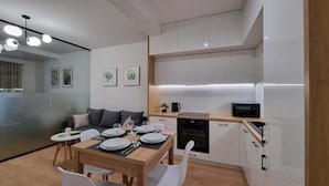 A modern kitchen with white cabinets, a microwave, a coffee maker, and a dishwasher. - Modern Studio in the Center | Balcony | Close to Market Square (Nowy Sącz)