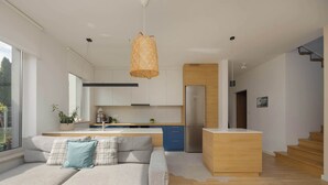 A modern kitchen with a central island, a built-in oven, and a refrigerator.