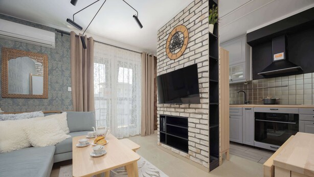 A modern living room with a sofa, a coffee table, and a fireplace.