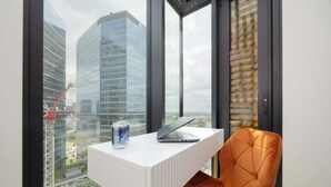 A modern office space with a white desk, a laptop, and a can of soda.