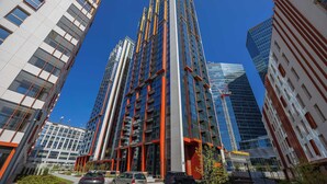A modern high-rise building with multiple floors, large windows, and a prominent central column.