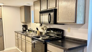 Una cocina moderna con armarios de madera, una estufa de acero inoxidable y un microondas.