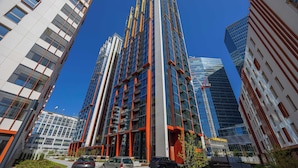 A modern high-rise building with multiple floors, large windows, and a prominent central column.