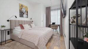 A modern bedroom with a bed, bedside table, and a desk with a chair.