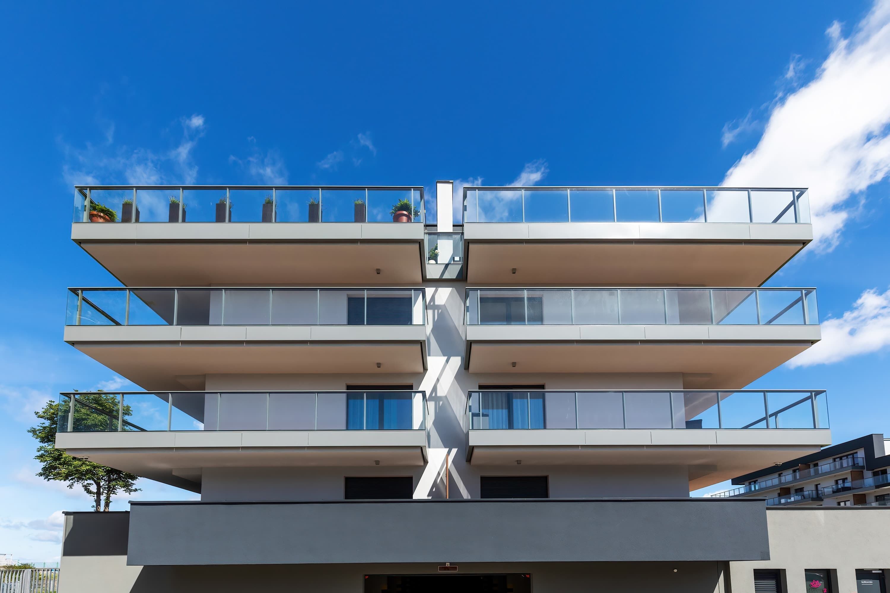 Un immeuble à plusieurs étages doté de balcons et de grandes fenêtres.