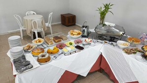 A buffet setup with various food items, including pastries, meats, and a buffet station with a toaster. - Hotel Transcontinental (Ji Parana)