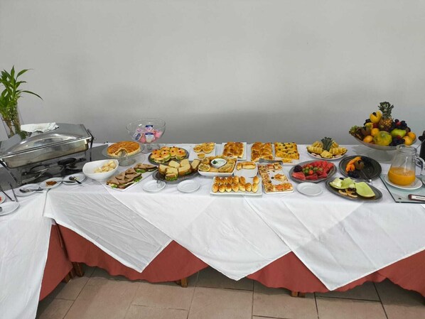 A buffet table with various food items and a fruit bowl. - Hotel Transcontinental (Ji Parana)