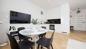 A modern kitchen with white cabinets, a black countertop, and a built-in oven.