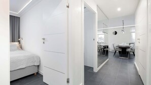 Una habitación de hotel moderna con cama, zona de comedor y cocina.
