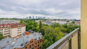 Un paysage urbain mêlant bâtiments modernes et bâtiments plus anciens, avec une variété de toits et un ciel nuageux.