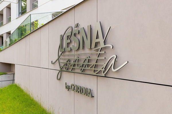 The building’s logo “Leśna Sonata” is elegantly displayed on the facade, adding a distinctive and refined touch to the entrance.