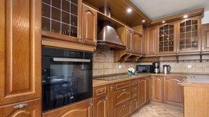 A kitchen with wooden cabinets, a stainless steel oven, and a tiled backsplash.