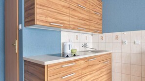 Eine moderne Küche mit Holzausstattung, einer weißen Arbeitsplatte und einem Wasserkocher.