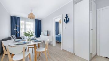 Un salon moderne comprenant un coin repas, un canapé, une table basse et un téléviseur.