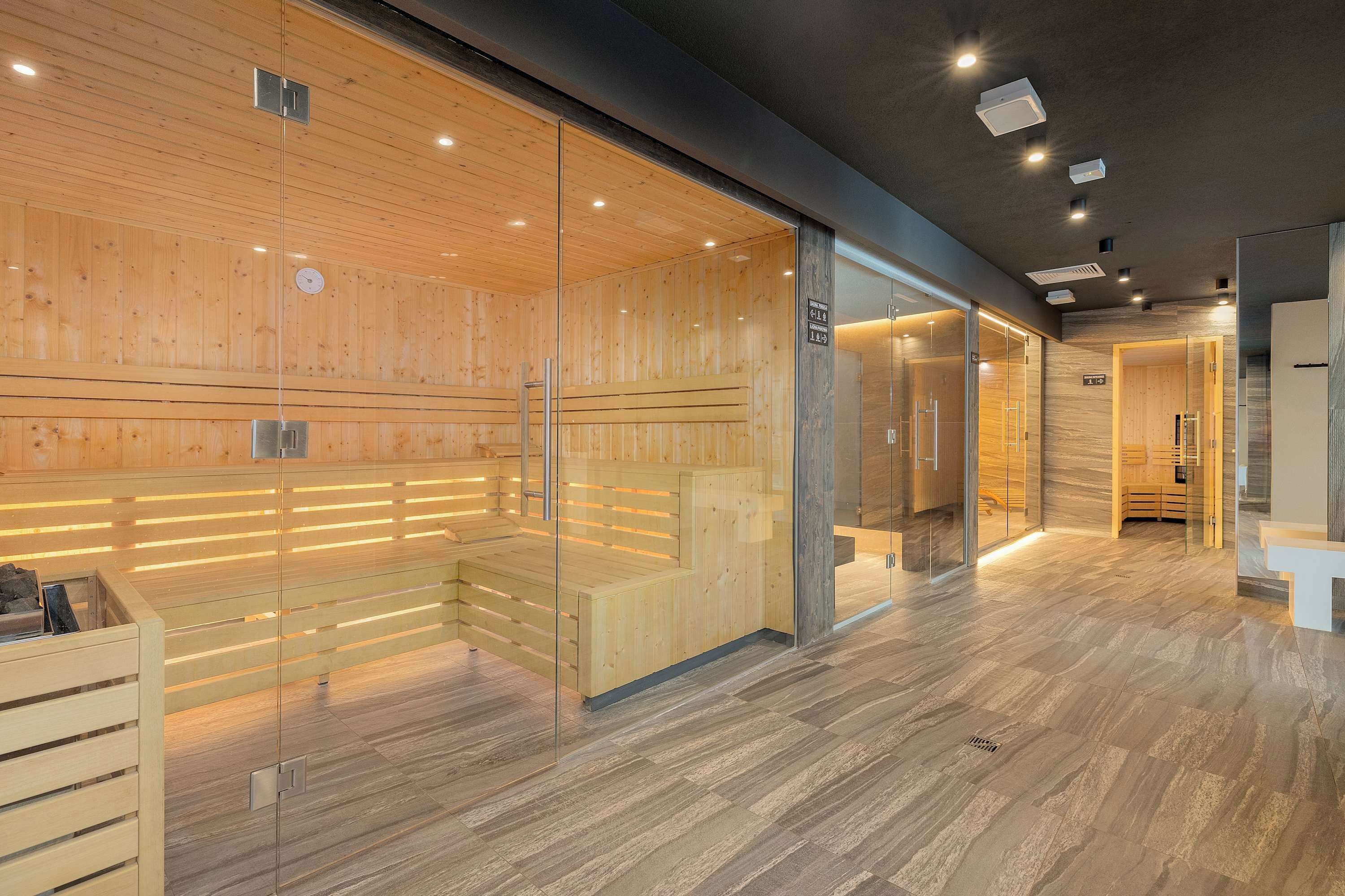 Een modern interieur met houten lambrisering, glazen scheidingswanden en een zitgedeelte.