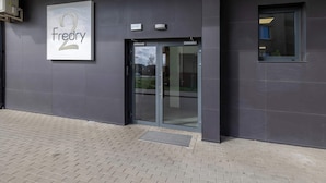 A building entrance with a sign reading "Fredry 2" and a small window to the right.