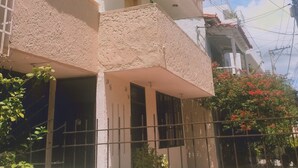 A two-story building with a balcony, a visible window, and a small entrance. - Casa del parque  (Cartagena)