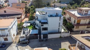 A multi-story residential building with a flat roof, solar panels, and a gated entrance. - Exclusive B&B Villa Rosa (Messina)